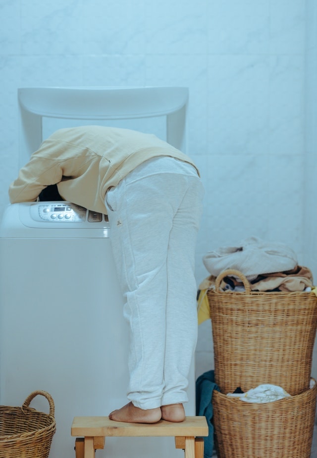 man cleaning washing machine in home